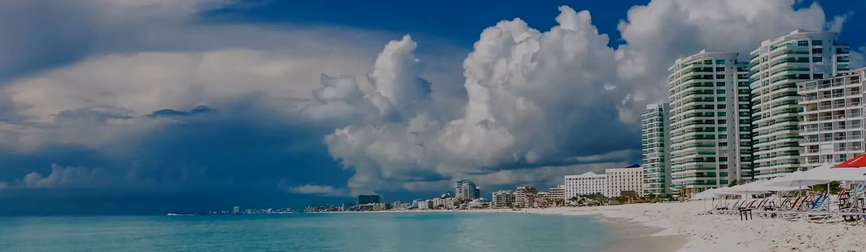 A fleet of Cancun Airport Transportation vans parked at a terminal, ready for passenger pickup.